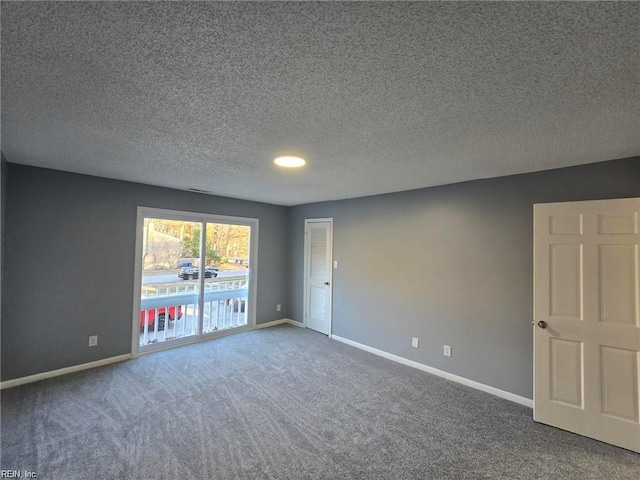 carpeted empty room featuring a textured ceiling