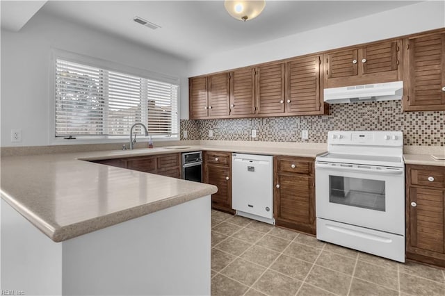 kitchen with tasteful backsplash, white appliances, sink, and light tile patterned floors