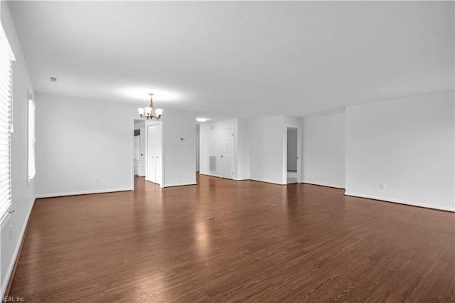 empty room featuring dark hardwood / wood-style floors and a chandelier