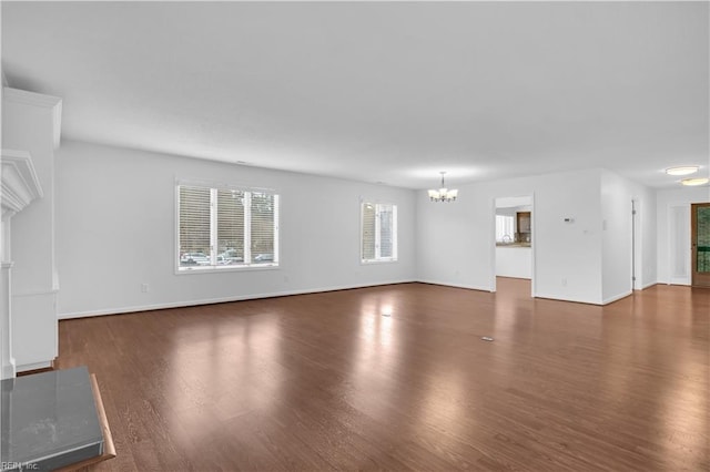 unfurnished living room with dark hardwood / wood-style flooring and a chandelier