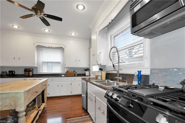 kitchen featuring sink, range with gas stovetop, white cabinetry, and crown molding