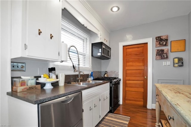 kitchen featuring white cabinets, appliances with stainless steel finishes, and dark hardwood / wood-style floors