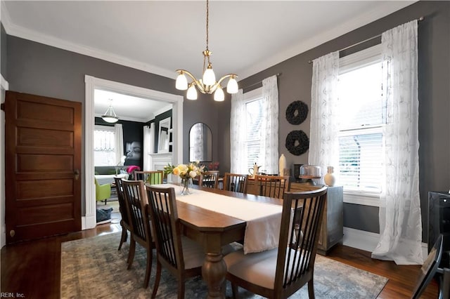 dining area with crown molding, dark hardwood / wood-style floors, and an inviting chandelier