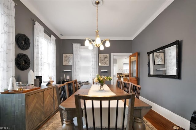 dining area with hardwood / wood-style floors, a chandelier, and ornamental molding