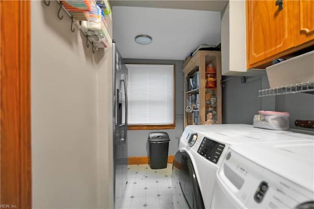 laundry area with washing machine and dryer and cabinets