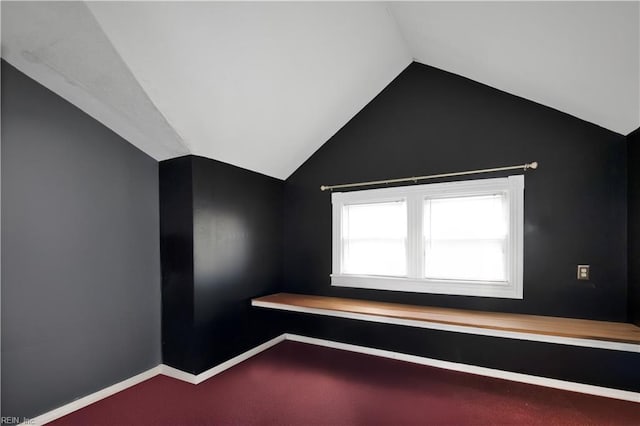 spare room with vaulted ceiling and carpet floors