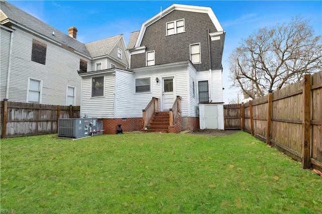 rear view of house with a yard and central AC unit