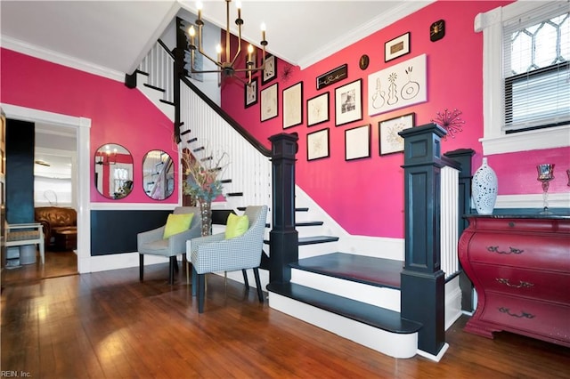 staircase with a notable chandelier, hardwood / wood-style flooring, and ornamental molding