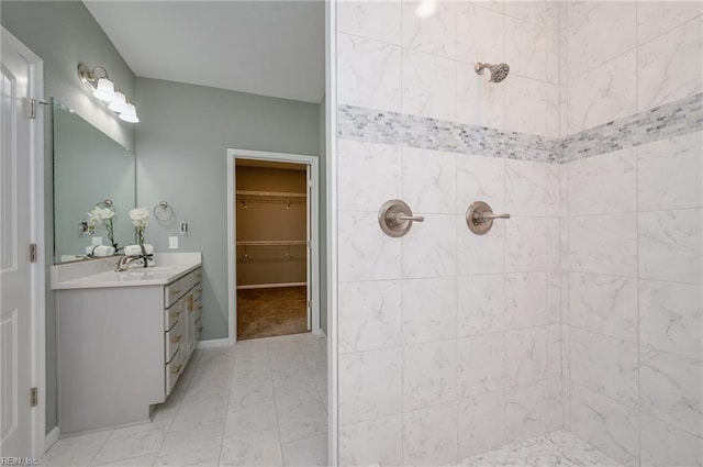 bathroom featuring a tile shower and vanity