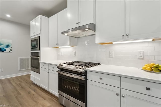 kitchen with stainless steel appliances, visible vents, light countertops, white cabinetry, and under cabinet range hood