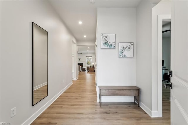 corridor with baseboards, recessed lighting, and light wood-style floors