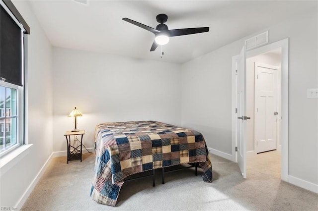 bedroom featuring baseboards, visible vents, and light colored carpet