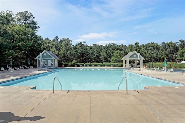 pool with a patio and fence