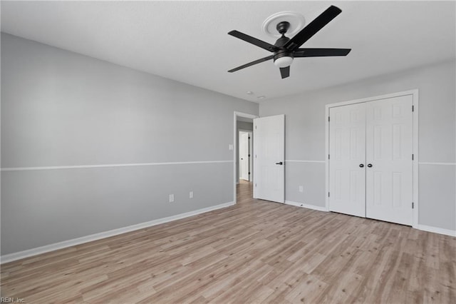 unfurnished bedroom featuring ceiling fan, light hardwood / wood-style floors, and a closet