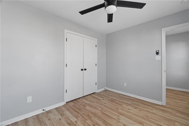 unfurnished bedroom featuring ceiling fan, light wood-type flooring, and a closet