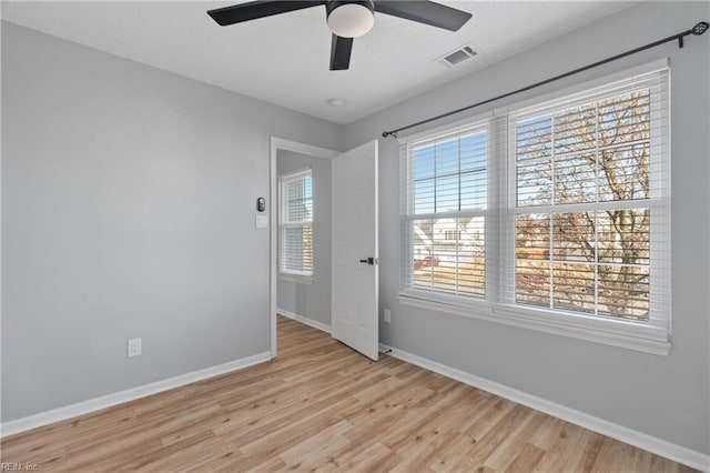 spare room with ceiling fan and light wood-type flooring