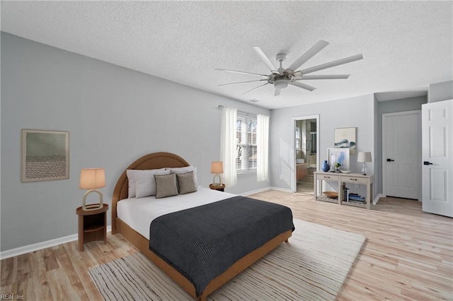 bedroom with ceiling fan, light hardwood / wood-style flooring, and a textured ceiling