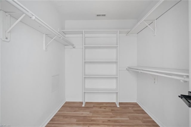 walk in closet with light wood-type flooring