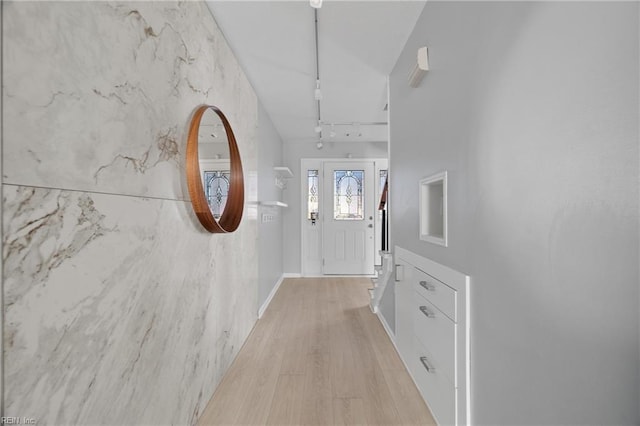 doorway to outside featuring rail lighting and light hardwood / wood-style flooring