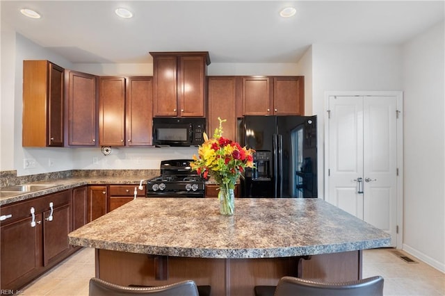 kitchen featuring a kitchen breakfast bar, a center island, and black appliances