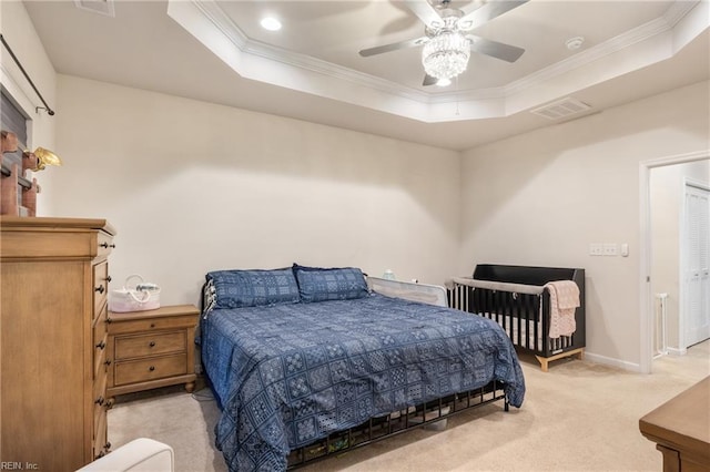 bedroom with crown molding, light colored carpet, a raised ceiling, and ceiling fan