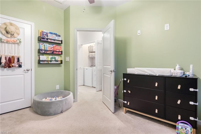 bedroom featuring washer / clothes dryer, light carpet, and ceiling fan