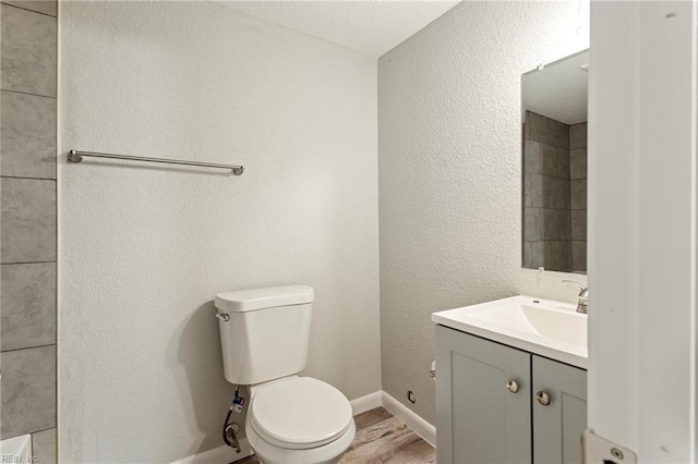 bathroom with vanity, wood-type flooring, and toilet