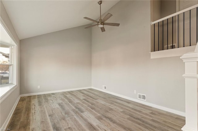 empty room with ceiling fan, vaulted ceiling, and hardwood / wood-style floors