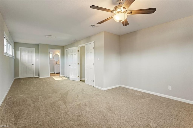 unfurnished bedroom featuring light colored carpet and ceiling fan