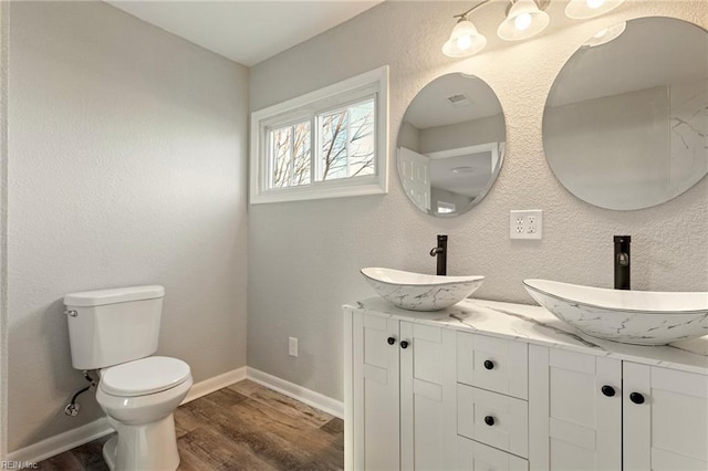 bathroom featuring wood-type flooring, vanity, and toilet