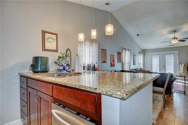 kitchen featuring french doors, a healthy amount of sunlight, light stone counters, and decorative light fixtures