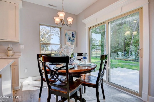 dining space featuring light hardwood / wood-style flooring and a notable chandelier