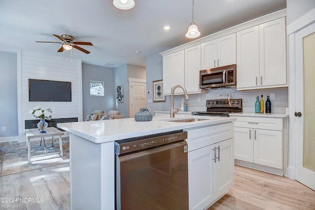 kitchen with white cabinetry, stainless steel appliances, sink, and pendant lighting