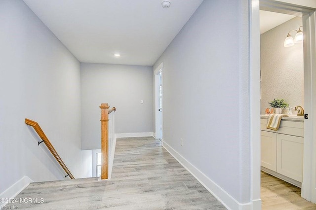 hallway featuring sink and light hardwood / wood-style floors