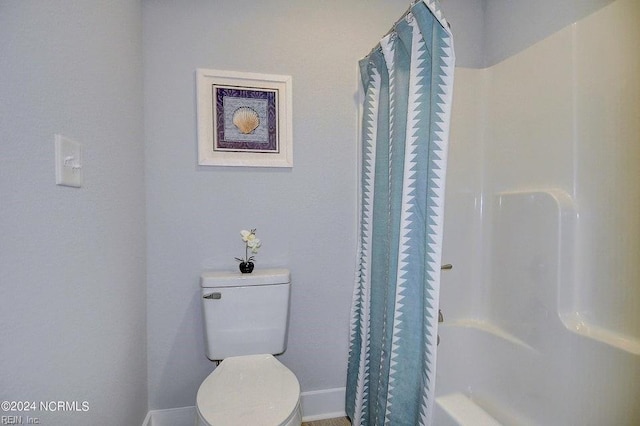 bathroom with curtained shower and toilet