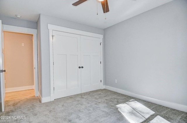 unfurnished bedroom featuring light colored carpet, ceiling fan, and a closet