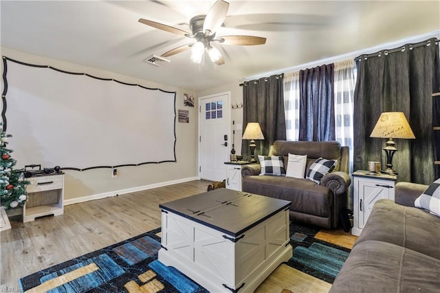 cinema featuring ceiling fan and light wood-type flooring