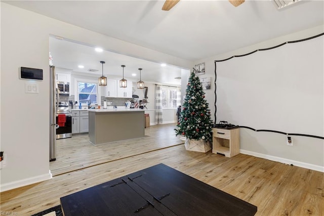 exercise area featuring light hardwood / wood-style floors and ceiling fan