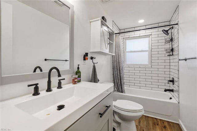 full bathroom with wood-type flooring, vanity, shower / bath combination with curtain, and toilet