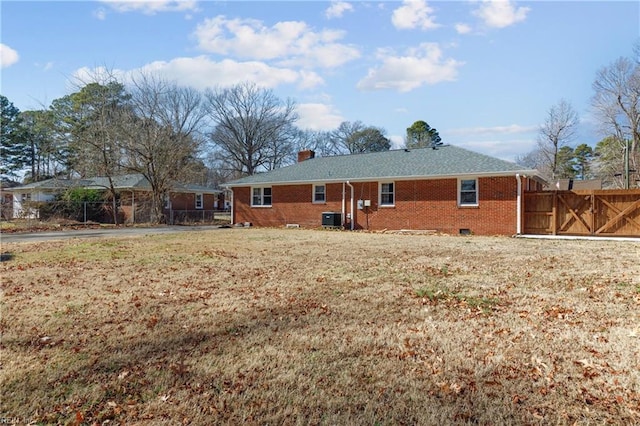 back of house with a yard and central air condition unit