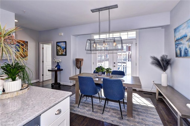 dining space featuring plenty of natural light, dark hardwood / wood-style floors, and french doors