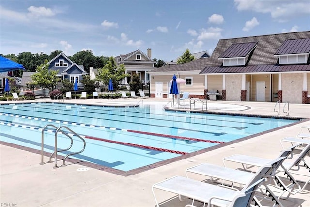 view of swimming pool featuring area for grilling and a patio area