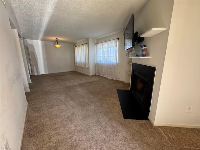 unfurnished living room featuring carpet floors and a textured ceiling