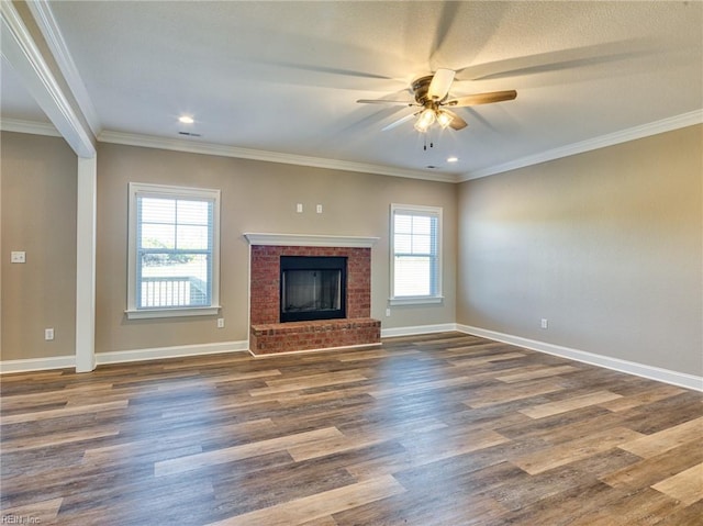 unfurnished living room featuring ornamental molding, plenty of natural light, dark hardwood / wood-style floors, and a fireplace