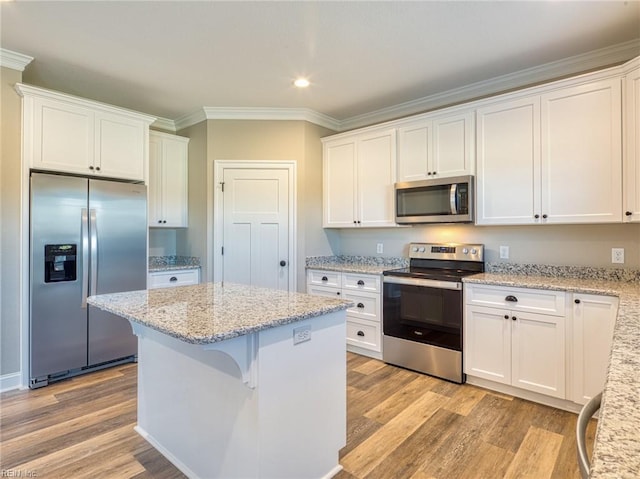 kitchen with light stone countertops, stainless steel appliances, and white cabinets