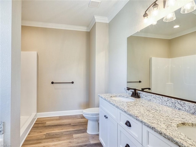 bathroom featuring crown molding, hardwood / wood-style floors, vanity, and toilet