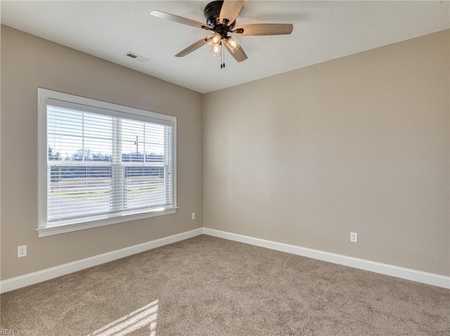 carpeted spare room featuring ceiling fan