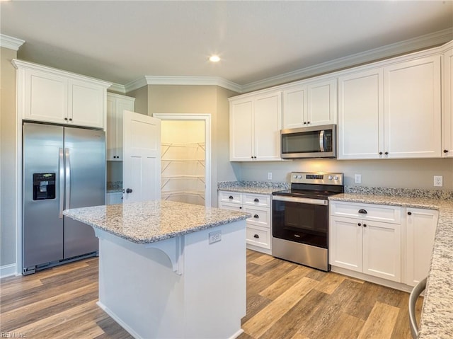 kitchen featuring light hardwood / wood-style flooring, light stone countertops, white cabinets, and appliances with stainless steel finishes