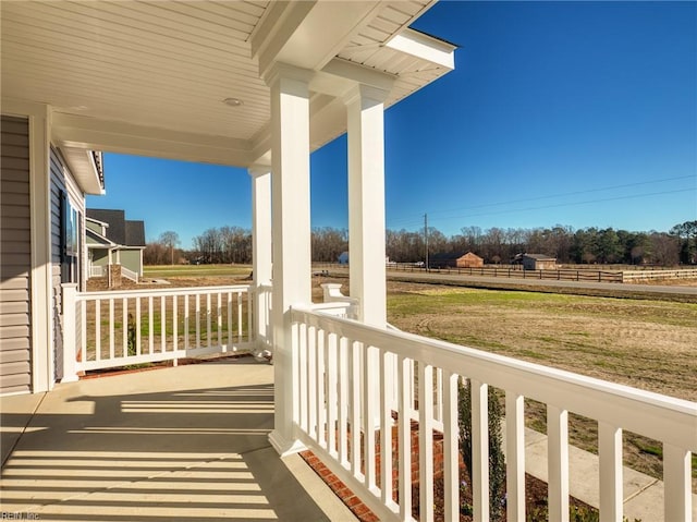 balcony with a rural view and a porch