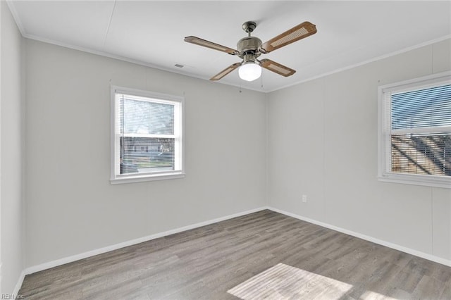 empty room with crown molding, ceiling fan, plenty of natural light, and light hardwood / wood-style flooring